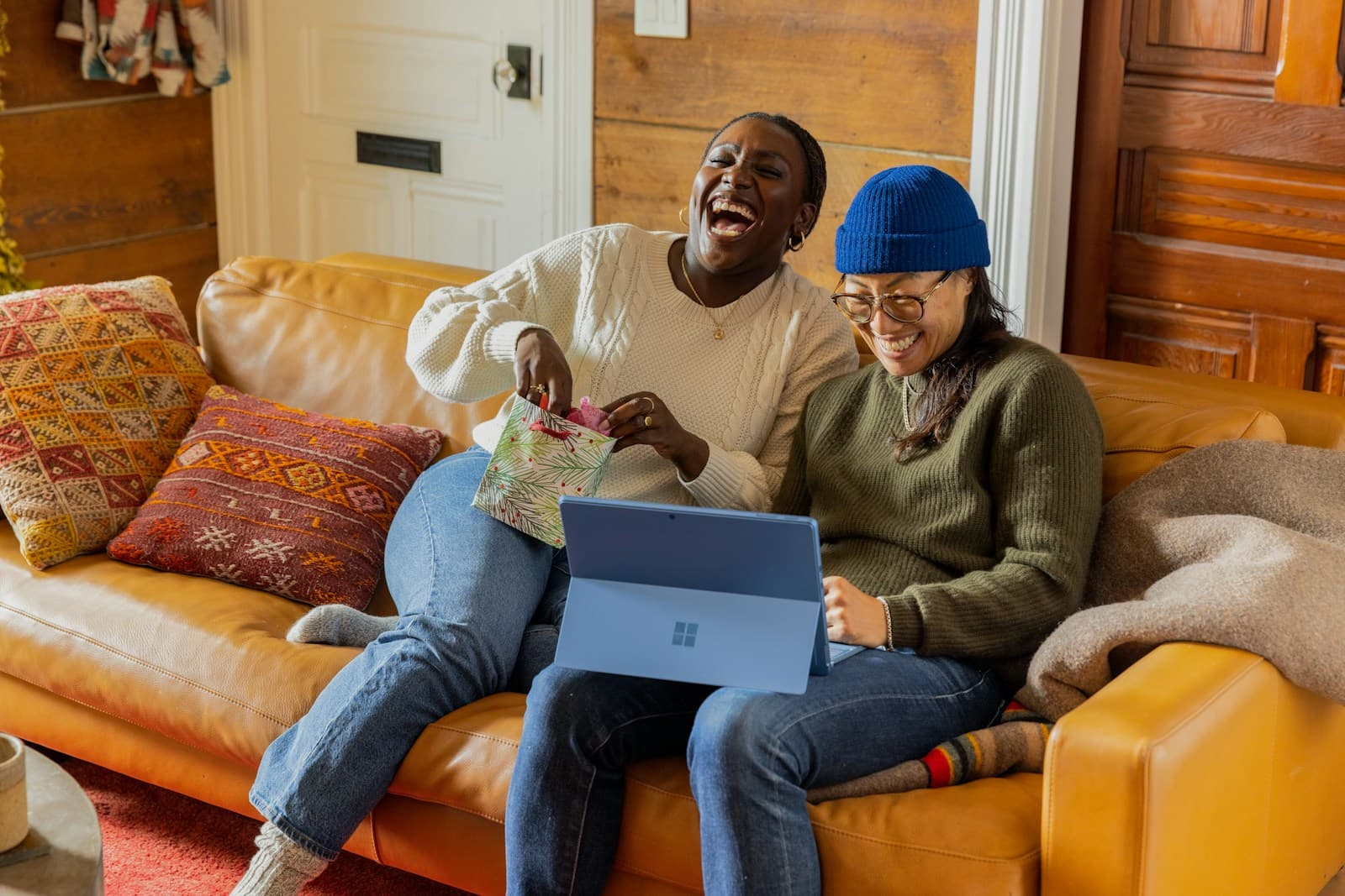 Two colleagues laughing together over a laptop
